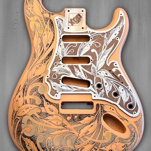 May include: A custom guitar body with detailed floral and leaf engravings. The body is a light peach colour with brown and white designs. The image includes the text "Dust Storm Engraving" and "Made in USA".
