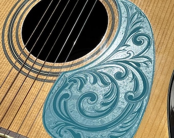 May include: Acoustic guitar with a light wood finish, featuring a blue pickguard with an engraved floral design. The guitar has black strings and a black soundhole. The text "DUST STORM ENGRAVING" is visible at the bottom.