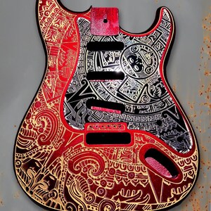 Peut inclure: Un corps de guitare rouge et noir avec des motifs gravés complexes. Le corps présente une zone centrale noire avec des accents argentés et un bord rouge. Le design comprend des motifs géométriques et circulaires. Le texte "DUST STORM ENGRAVING" est visible.