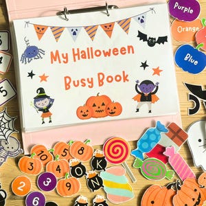May include: A Halloween-themed busy book with colorful illustrations and the text "My Halloween Busy Book." Includes number cards, pumpkin cutouts, and color labels. A fun educational activity for kids.