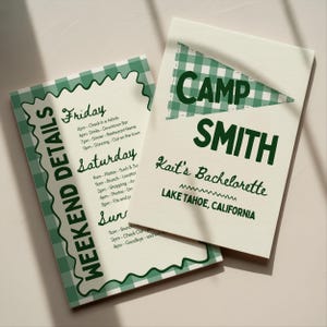 May include: Two cream-colored cards with green gingham accents. One card reads "Weekend Details" with a schedule. The other card says "Camp Smith, Kait's Bachelorette, Lake Tahoe, California."