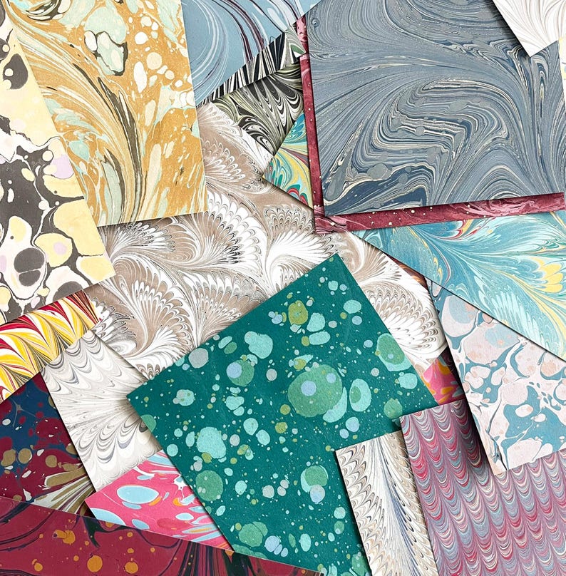 May include: Assortment of colorful marbled paper sheets in various patterns and colors, including teal, pink, red, blue, and white.