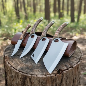 Op de afbeelding: Een set van vier messen met houten handvatten en zilveren bladen, gepresenteerd op een boomstronk. De messen omvatten een vleesmes. Achter de messen bevindt zich een bruine leren etui.