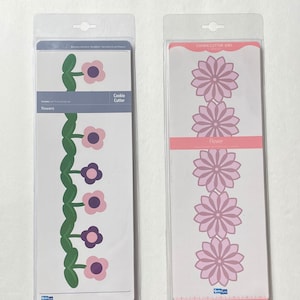 May include: Two packages of cookie cutters, one with a border of flowers and leaves and the other with three different sized flowers. The package with the border is labeled "Cookie Cutter" and "Flowers". The package with the three flowers is labeled "Cookie Cutter Dies" and "Flower".