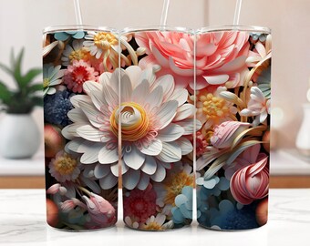 Op de afbeelding: Drie roestvrijstalen bekers met een bloemenontwerp. Het ontwerp bevat witte, roze en gele papieren bloemen op een donkere achtergrond.