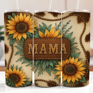Puede incluir: Un vaso blanco con un patr&oacute;n de piel de vaca marr&oacute;n y girasoles. El vaso tiene un parche de cuero marr&oacute;n con la palabra "MAMA" en letras doradas.