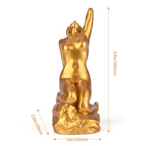 May include: A gold-colored sculpture of a kneeling figure with one arm raised. The sculpture is 3.9 inches (100mm) tall, 2.5 inches (63mm) wide, and 1.6 inches (40mm) deep. The figure is kneeling on a textured base.