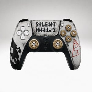 May include: A black and white game controller featuring the text SILENT HILL 2 on the centre touchpad. The controller includes gold-coloured bullet casing thumbsticks and action buttons, a black silhouette graphic, and a red triangular symbol.