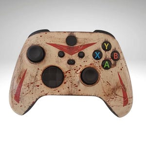 May include: A white and red Xbox controller with a distressed paint finish. The controller has a black d-pad, black buttons, and a black faceplate.