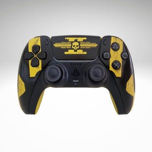 May include: Black and yellow custom video game controller. The controller has a skull and crossbones design in yellow on the top centre. Yellow accents are on the sides and around the buttons. The controller has a matte finish.