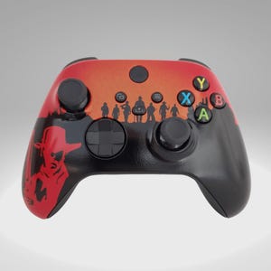 May include: A custom Xbox controller with a red and black design. The controller features a silhouette of cowboys and a sunset scene. The buttons are colored green, blue, yellow, and red.