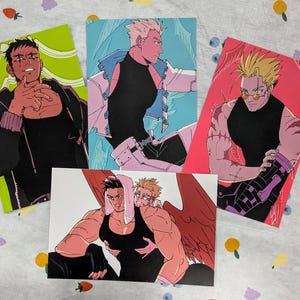 May include: Four illustrated cards featuring different characters. Each card has a white background with a colourful illustration of a character. The characters are all male and have different hairstyles and clothing.
