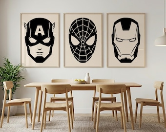 May include: Three framed black and white superhero portraits hang above a wooden dining table. The portraits feature Captain America, Spider-Man, and Iron Man. The room has a neutral color palette with wooden chairs and a green plant.