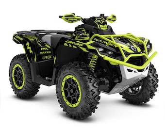 May include: Black and green Can-Am Outlander 900 ATV with a Fox Racing sticker on the front. The ATV has a black roll cage and a black and green graphic design.