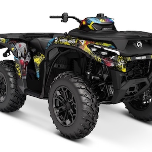 May include: A black Can-Am off-road vehicle with a colourful graphic design featuring a clown face. The vehicle has black wheels with a black and silver rim.