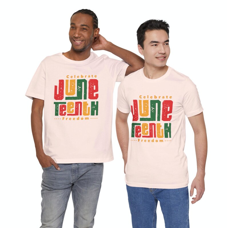 Puede incluir: Dos personas con camisetas blancas con el texto "Celebrate Juneteenth...Freedom..." impreso en rojo, verde y amarillo. Las camisetas celebran el Juneteenth, un d&iacute;a festivo que conmemora la emancipaci&oacute;n de los afroamericanos esclavizados.