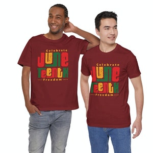 Puede incluir: Dos personas con camisetas marrones con el texto "Celebrate Juneteenth...Freedom..." impreso en rojo, amarillo y verde.