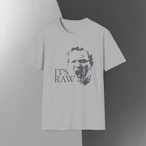 May include: A grey t-shirt with a black and white image of a man's face and the text "IT'S RAW".