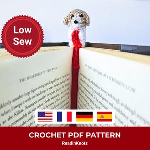Puede incluir: Un marcapáginas de ganchillo con forma de perro, insertado en un libro abierto. El perro tiene la cabeza de color beige y el cuerpo blanco con una cola roja. El libro está abierto en una página con texto impreso. También se ve el texto "Low Sew" y "CROCHET PDF PATTERN".