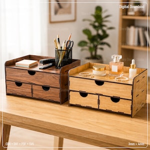May include: Two wooden desktop organisers with two drawers each, one in dark walnut and one in light oak finish. The dark organiser holds a black mesh pencil cup with pens and a stapler. The light organiser holds a perfume bottle and jewellery.