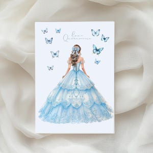 May include: A rectangular card featuring a watercolor illustration of a woman in a light blue ball gown. The card is adorned with blue butterflies and the text "Love Quincea&ntilde;era" in cursive.