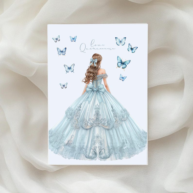 May include: A light blue quincea&ntilde;era card featuring a watercolor illustration of a woman in a ball gown. The dress has intricate lace details and a large bow. Butterflies and the words "Love, Quincea&ntilde;era" are also featured.