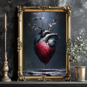 May include: A framed artwork featuring a stylized anatomical heart with a red center and dark blue and gold accents. The heart has a tree growing from it, and is set against a dark background. The frame is ornate gold.