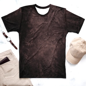 Könnte beinhalten: Ein braunes T-Shirt mit einem abgenutzten, verblassten Look. Das Shirt hat einen Rundhalsausschnitt und kurze Ärmel.