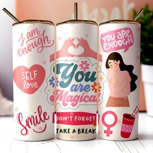 Puede incluir: Tres vasos de acero inoxidable con diseños en rosa y blanco. Los vasos presentan frases motivacionales como "Soy suficiente", "Eres mágico" y "Eres suficiente".