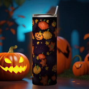 May include: A cylindrical tumbler with a dark purple background featuring a repeating pattern of orange pumpkins, jack-o'-lanterns, and autumn leaves. The tumbler includes a clear lid and a thin, straight straw extending from the top centre.
