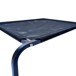 May include: Black metal elevated pet bed with a black mesh fabric top. The bed has a single leg visible in the image.