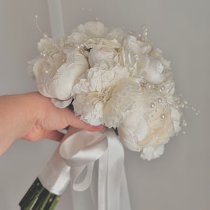 white bridal bouquet and boutonniere with pearl detail