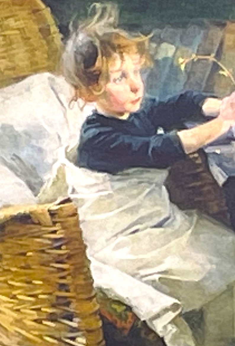 以下が含まれることがあります： 金髪の若い女の子が、籐のバスケットに座っています。白いドレスと濃い青色のセーターを着ています。彼女は右を見て、考え込んでいる表情をしています。