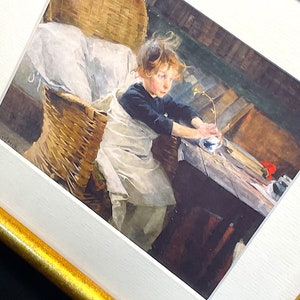 以下が含まれることがあります： 籐の椅子に座った若い女の子を描いた水彩画。白いエプロンと青いシャツを着ています。彼女は青と白のカップに小さな植物を持っています。絵は、木製のテーブルと背景に赤い花のある素朴なインテリアに設定されています。