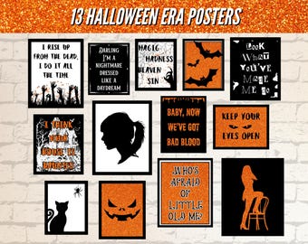 May include: A collection of 13 Halloween-themed posters with black frames. The posters feature various spooky designs and quotes, including bats, silhouettes, and phrases like "I Rise Up From The Dead" and "Keep Your Eyes Open". The background is a brick wall.