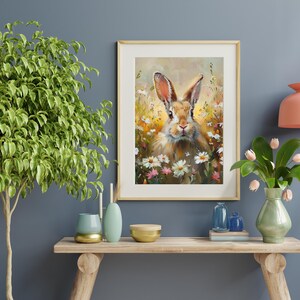 May include: A painting of a brown rabbit sitting in a field of white and pink flowers. The rabbit is looking directly at the viewer.