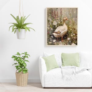 May include: A white duck with a yellow beak stands in a field of green grass and colorful flowers. The duck is facing to the right and has its head turned to the left. The background is a soft, blurred green and brown.