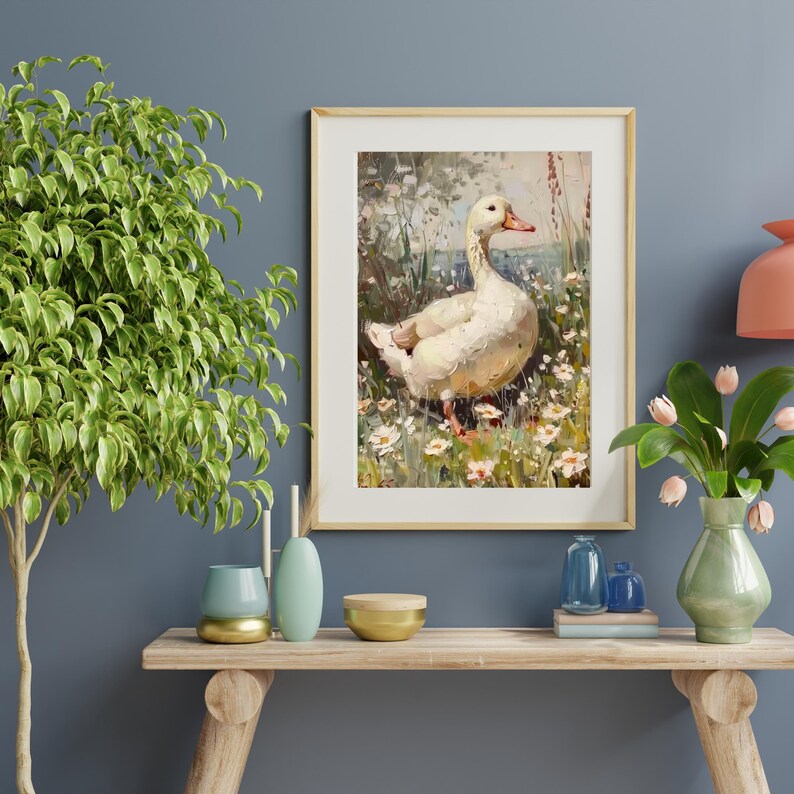 May include: A framed painting of a white duck standing in a field of wildflowers. The duck is facing to the right and has its head turned to the left. The background is a blurred image of green trees and a blue sky.