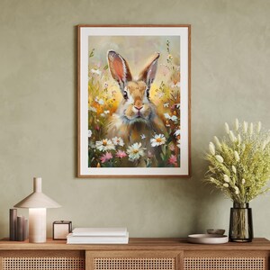 May include: A painting of a brown rabbit with white fur on its chest and ears, sitting in a field of white and pink flowers. The rabbit is looking directly at the viewer.