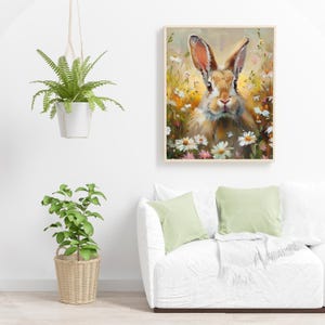 May include: A painting of a brown rabbit with white fur around its face, sitting in a field of white and pink flowers. The rabbit is looking directly at the viewer.