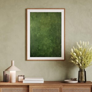 May include: A framed abstract art print with a textured green surface. The artwork is displayed in a wooden frame with a white mat. The image is part of a home decor theme.