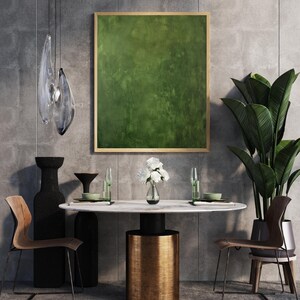 May include: A modern dining room setting featuring a round marble table with a gold base, surrounded by wooden chairs. A large green abstract painting hangs above the table. Decorative vases, glassware, and a potted plant complete the scene.
