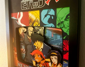 May include: A framed 3D pop-up art piece featuring characters from the anime series Cowboy Bebop. The characters are Spike Spiegel, Jet Black, Faye Valentine, Ed, and Ein. The title "Cowboy Bebop" is written in Japanese and English. The text "See You Space Cowboy..." is written at the bottom of the frame.