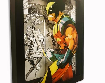 May include: A framed comic art piece featuring Wolverine in a dynamic pose. The artwork is a 3D layered design with vibrant colors, set against a black and white comic panel background. The frame is black, and the piece includes the text "SNIKT!" and "HRAK!"