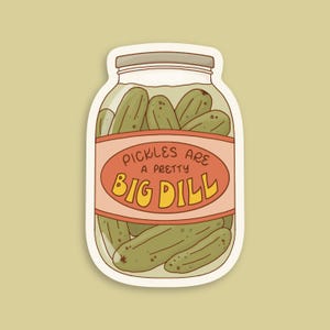 Peut inclure: Un autocollant découpé représentant un bocal en verre rempli de cornichons verts. Le bocal porte une étiquette couleur pêche avec le texte "PICKLES ARE A PRETTY BIG DILL" en lettres brunes et jaunes. Le couvercle est brun clair et le design est illustré.