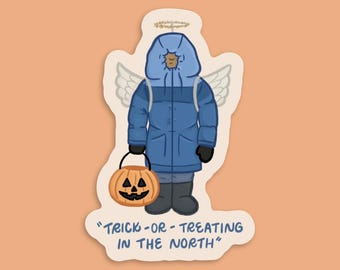 May include: A sticker featuring a cartoon illustration of a figure in a blue winter coat, angel wings, and a halo, holding a jack-o'-lantern. The text "TRICK-OR-TREATING IN THE NORTH" is at the bottom.