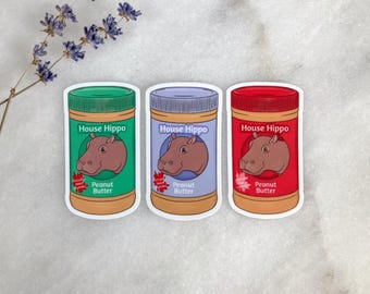 May include: Three stickers of peanut butter jars with different colored lids and labels. Each jar features a cartoon hippo and the text "House Hippo Peanut Butter". The jars have green, purple, and red lids.