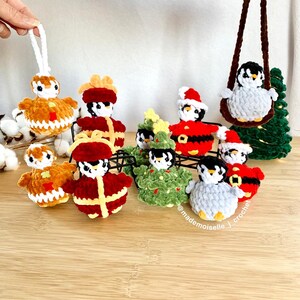 No sew crochet patterns of penguins with theme of Christmas. Showing them together, with one showing a car hanger penguin and one Christmas ornament penguin. By Mademoiselle J Crochet