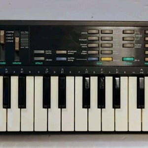 以下が含まれることがあります： 白と黒の鍵盤を備えた黒いカシオSK-1サンプリングキーボード。コントロールパネルには、さまざまなボタン、音量とモード用の2つの垂直スライダーがあり、CASIO SK-1およびSAMPLING KEYBOARDというテキストが白と緑で印刷されています。