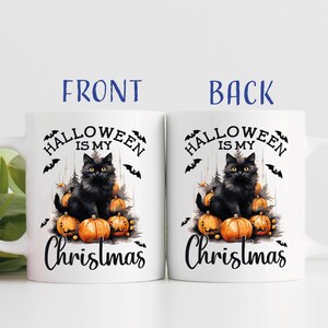 Puede incluir: Taza de cer&aacute;mica blanca con un gato negro sentado sobre una pila de calabazas naranjas. La taza dice "Halloween is my Christmas".